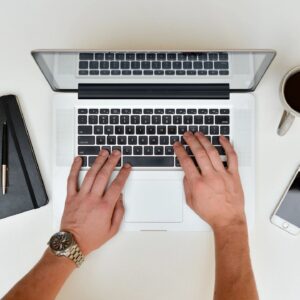 A legal professional reviewing billing documents and using legal billing software on a laptop, symbolizing efficient law firm billing practices and best practices for tracking billable hours.